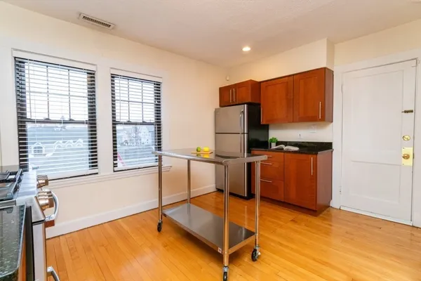 a kitchen with stainless steel appliances granite countertop a refrigerator and a stove top oven