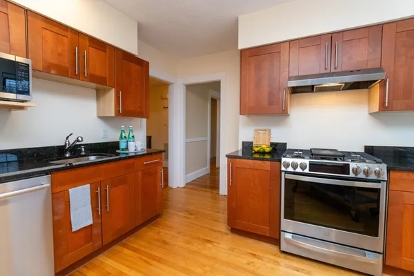 a kitchen with stainless steel appliances granite countertop a stove a sink and a refrigerator
