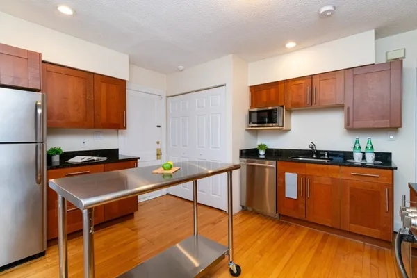 a kitchen with stainless steel appliances granite countertop a stove a sink and a refrigerator