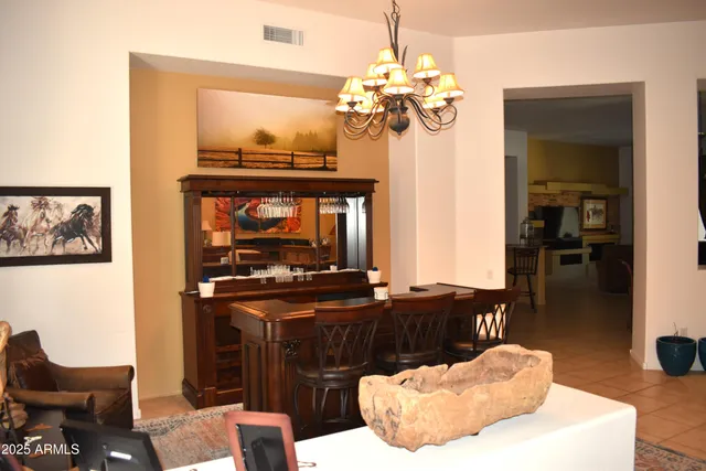 a living room with chandelier and a fireplace