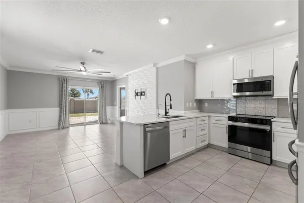a large kitchen with stainless steel appliances granite countertop a stove and cabinets