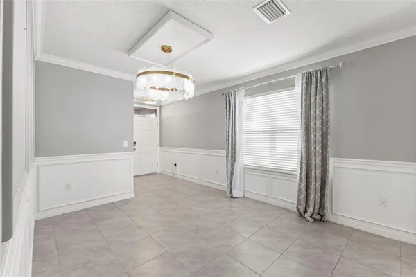 an empty room with a ceiling fan and window