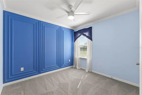 an empty room with windows and a chandelier fan