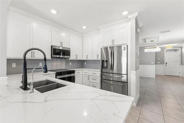 a kitchen with stainless steel appliances kitchen island granite countertop a refrigerator sink and stove