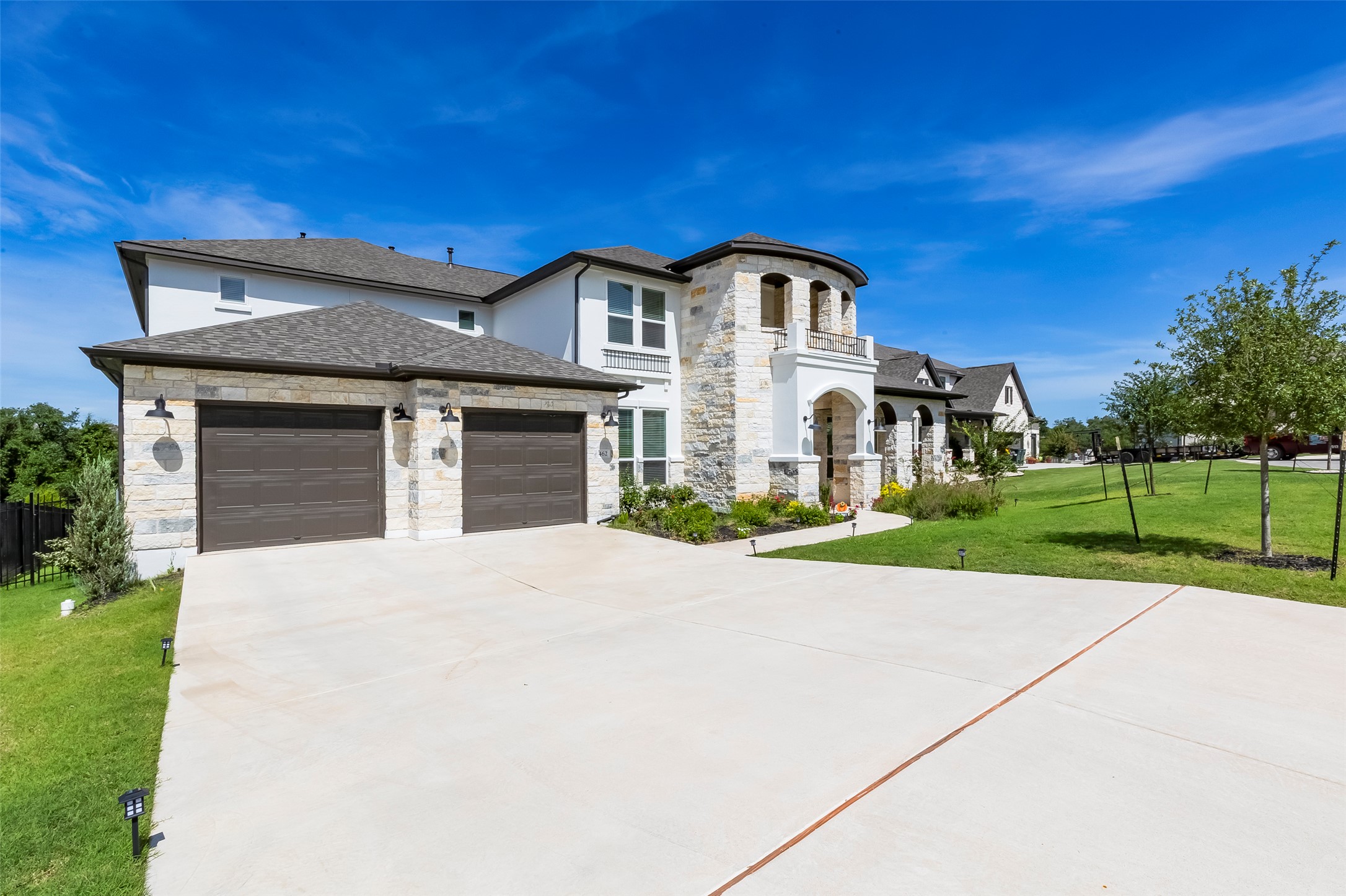 462 Old Stone Road Austin, TX 78737 - Photo 2 of 39 View of front of property featuring an attached garage, stone siding, driveway, roof with shingles, and a balcony