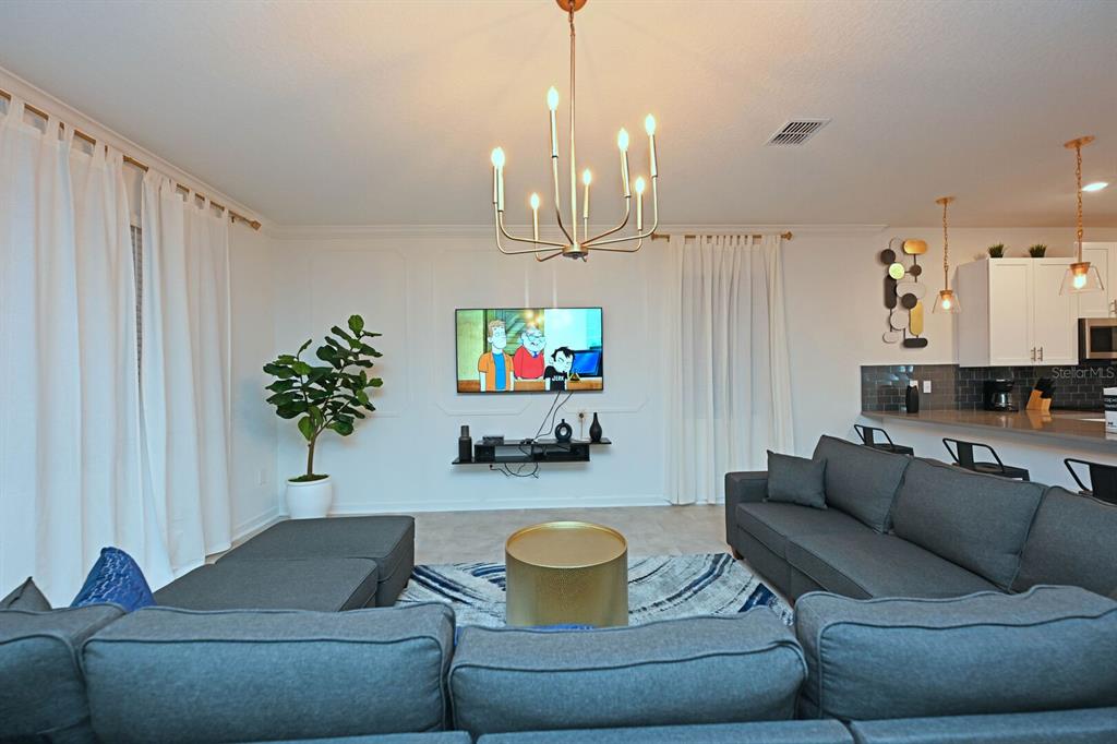 2956 Penelope Loop Kissimmee, FL 34746 - Photo 28 of 94 a living room with furniture and a chandelier