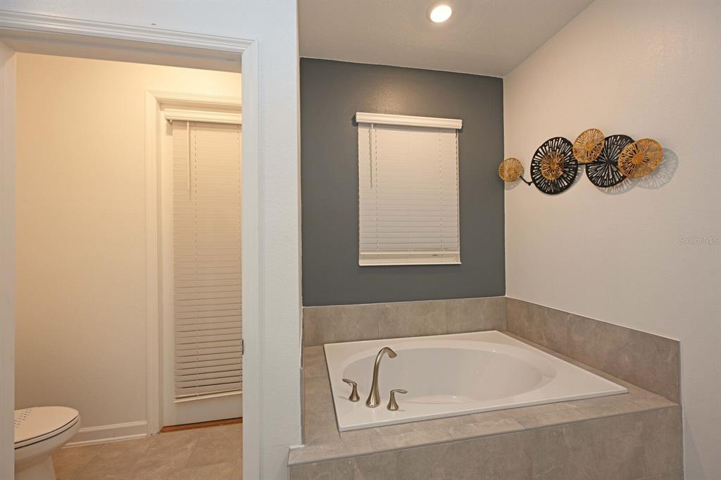 2956 Penelope Loop Kissimmee, FL 34746 - Photo 35 of 94 a bathroom with a tub and a window