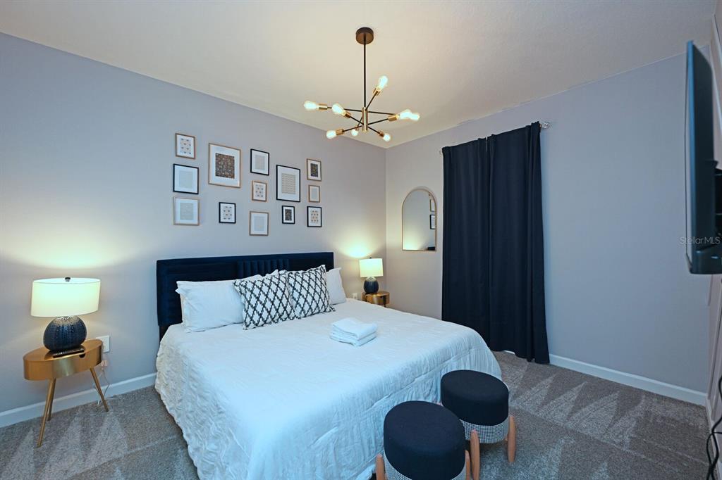 2956 Penelope Loop Kissimmee, FL 34746 - Photo 36 of 94 a bedroom with a bed and a chandelier