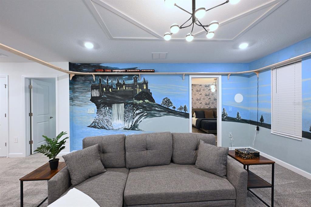 2956 Penelope Loop Kissimmee, FL 34746 - Photo 49 of 94 a living room with furniture and a chandelier