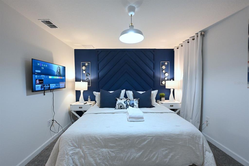 2956 Penelope Loop Kissimmee, FL 34746 - Photo 62 of 94 a bedroom with a bed and a flat screen tv