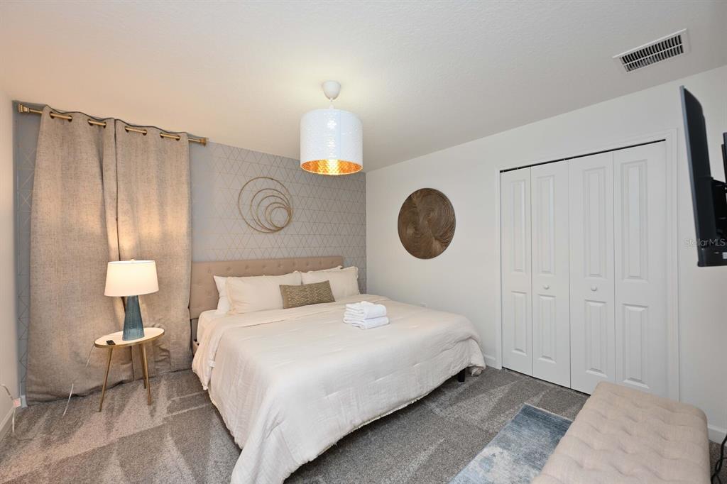 2956 Penelope Loop Kissimmee, FL 34746 - Photo 69 of 94 a bedroom with a bed and a lamp on table