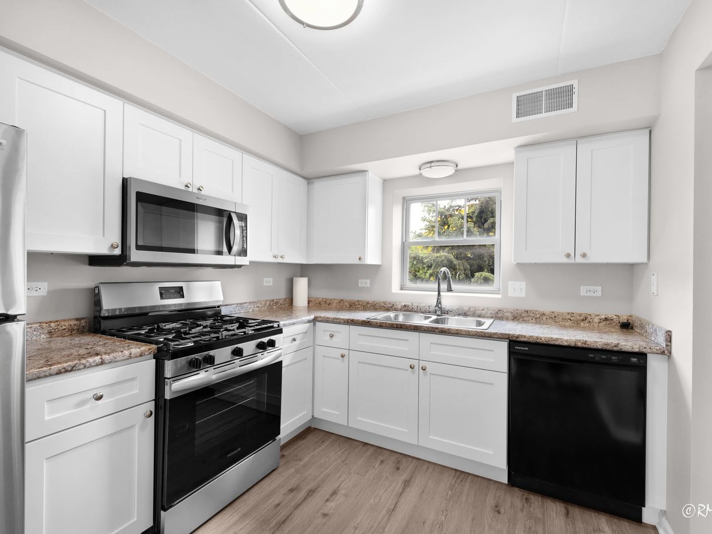 237 North Mill Road, Unit 12 Addison, IL 60101 - Photo 18 of 21 a kitchen with granite countertop a stove a sink and dishwasher a microwave oven with wooden floor