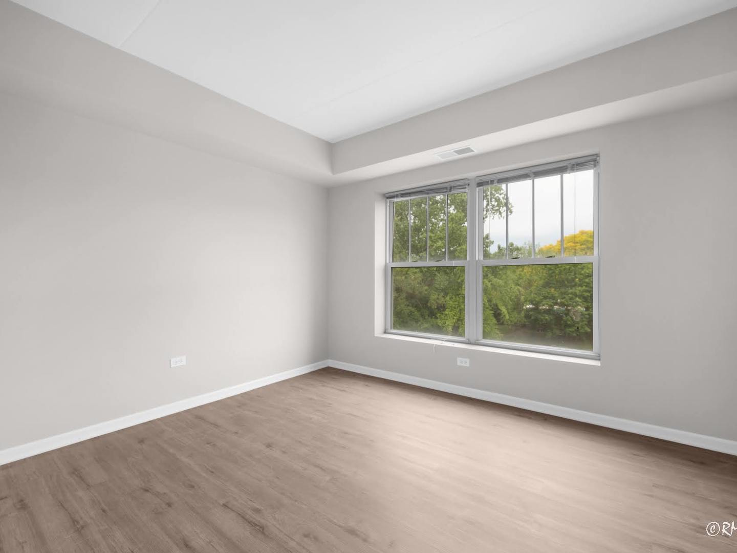 237 North Mill Road, Unit 12 Addison, IL 60101 - Photo 9 of 21 an empty room with wooden floor and windows