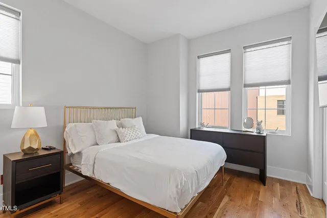 a bedroom with a bed and wooden floor