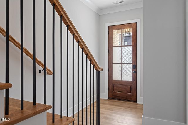 a view of staircase with lots of frames on wall and a window