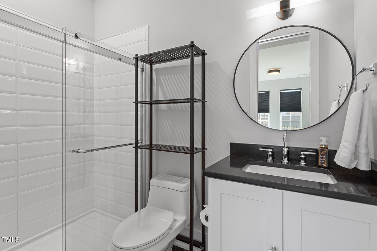 613 South West Street Raleigh, NC 27601 - Photo 10 of 37 a bathroom with a sink a toilet and a mirror