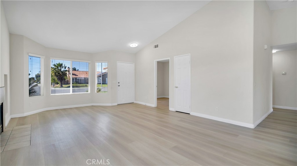 19364 Summerwind Trail Perris, CA 92570 - Photo 11 of 50 a view of an empty room with wooden floor and a window