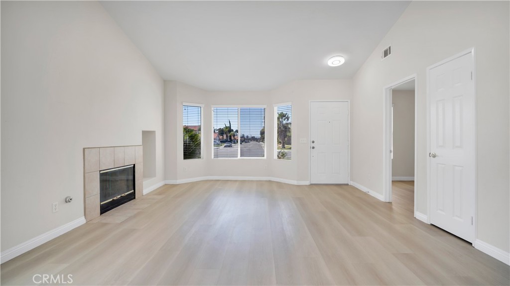 19364 Summerwind Trail Perris, CA 92570 - Photo 15 of 50 an empty room with wooden floor and fireplace