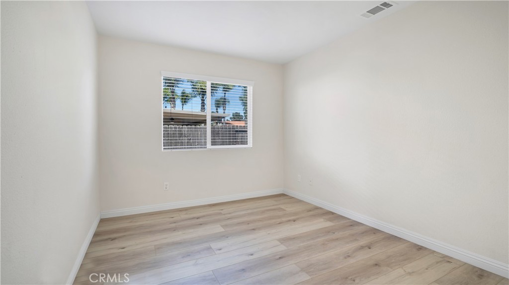 19364 Summerwind Trail Perris, CA 92570 - Photo 23 of 50 an empty room with wooden floor and windows