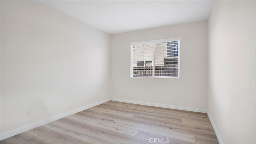 19364 Summerwind Trail Perris, CA 92570 - Photo 25 of 50 a view of an empty room with wooden floor and a window