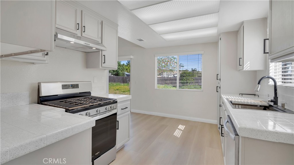 19364 Summerwind Trail Perris, CA 92570 - Photo 6 of 50 a kitchen with stainless steel appliances granite countertop a sink stove and cabinets