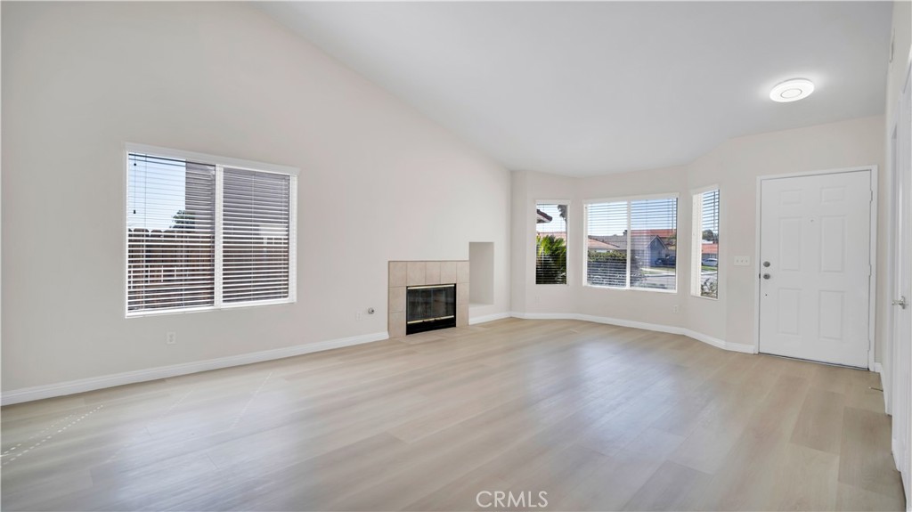 19364 Summerwind Trail Perris, CA 92570 - Photo 10 of 50 an empty room with wooden floor fireplace and windows
