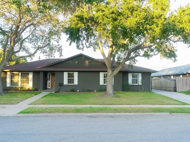 a white house that has a tree in front of it