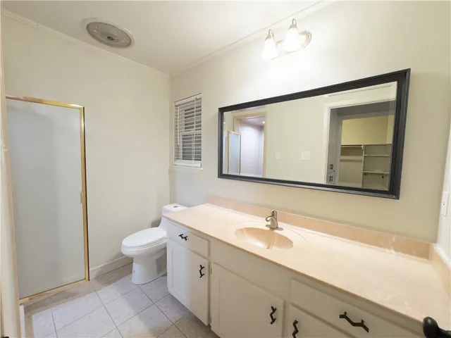 a bathroom with a granite countertop sink mirror and toilet