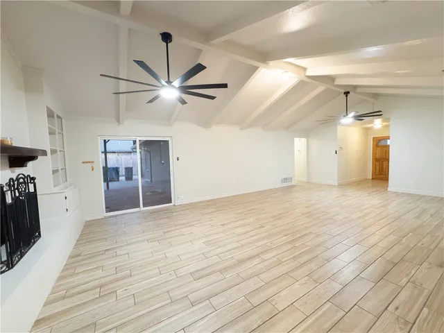 a view of a livingroom with a ceiling fan and wooden floor