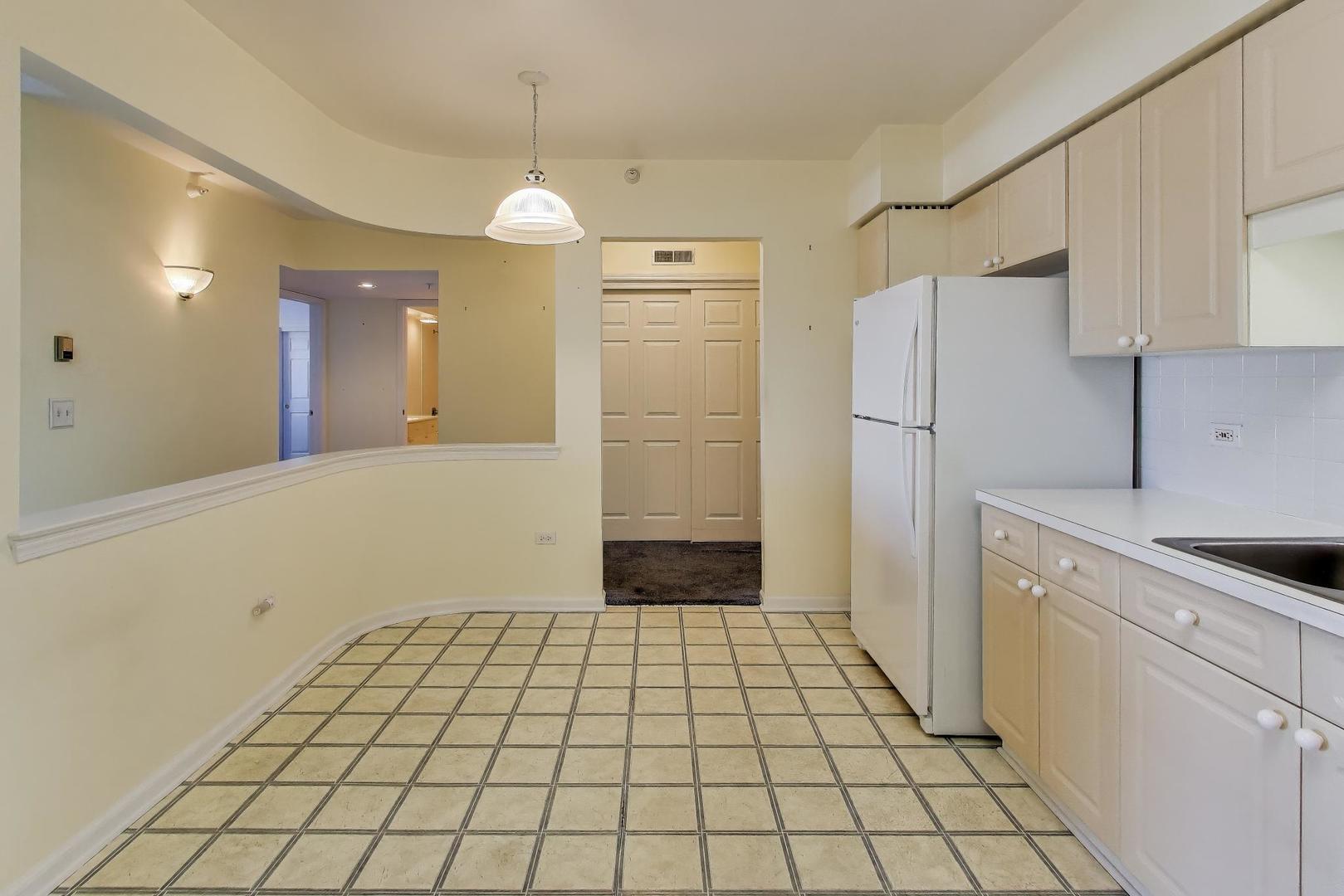 650 South River Road, Unit 812 Des Plaines, IL 60016 - Photo 12 of 25 a view of a kitchen with a sink and an empty room