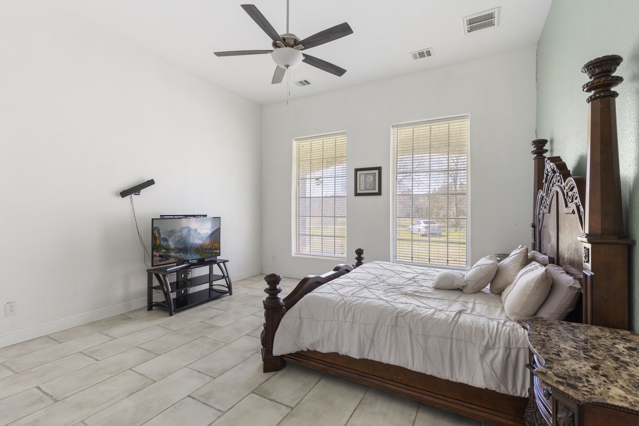 2464 North Walker Road Cleveland, TX 77328 - Photo 30 of 42 a bedroom with a bed a chair and a chandelier
