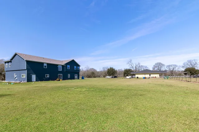 a view of a brick house with many windows and a yard