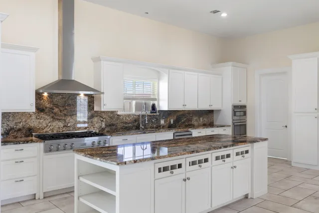 a kitchen with stainless steel appliances granite countertop a stove top oven a sink a counter top space and cabinets