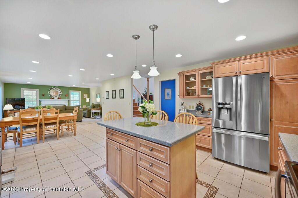 47 Wildernest Road Moscow, PA 18444 - Photo 14 of 40 a kitchen with stainless steel appliances granite countertop a refrigerator a sink dishwasher a dining table and chairs with wooden floor