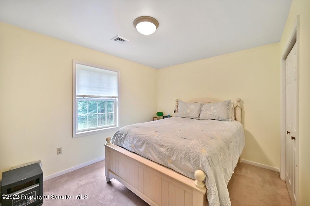 47 Wildernest Road Moscow, PA 18444 - Photo 31 of 40 a bed sitting in a bedroom next to a window