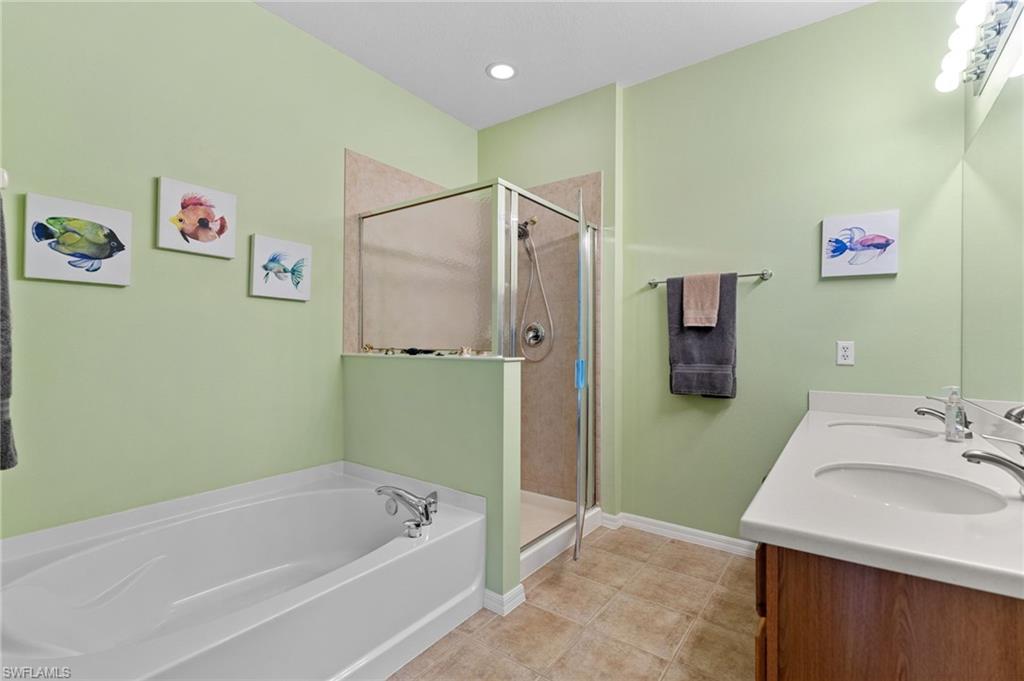 2780 Orange Grove Trail Naples, FL 34120 - Photo 14 of 29 Bathroom featuring a garden tub, a stall shower, and double vanity