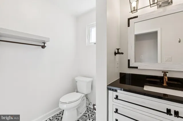 a bathroom with a sink a toilet and a mirror