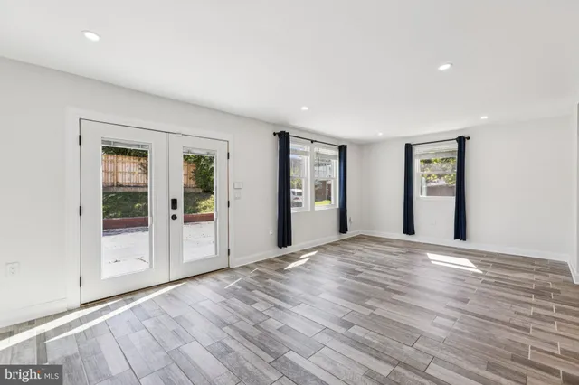 a view of a big room with wooden floor and windows