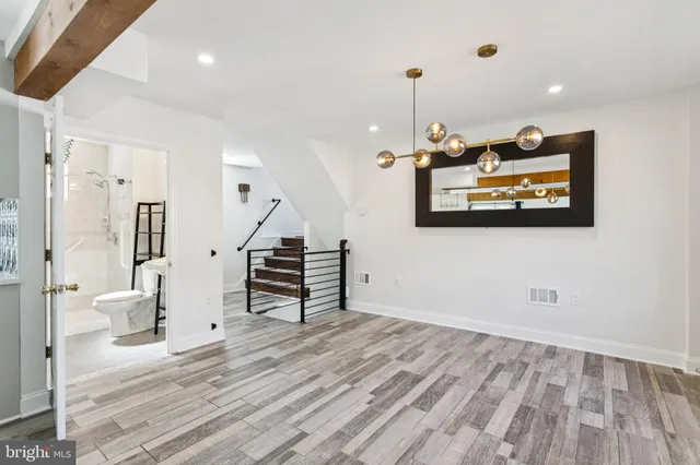 an empty room with wooden floor and staircase