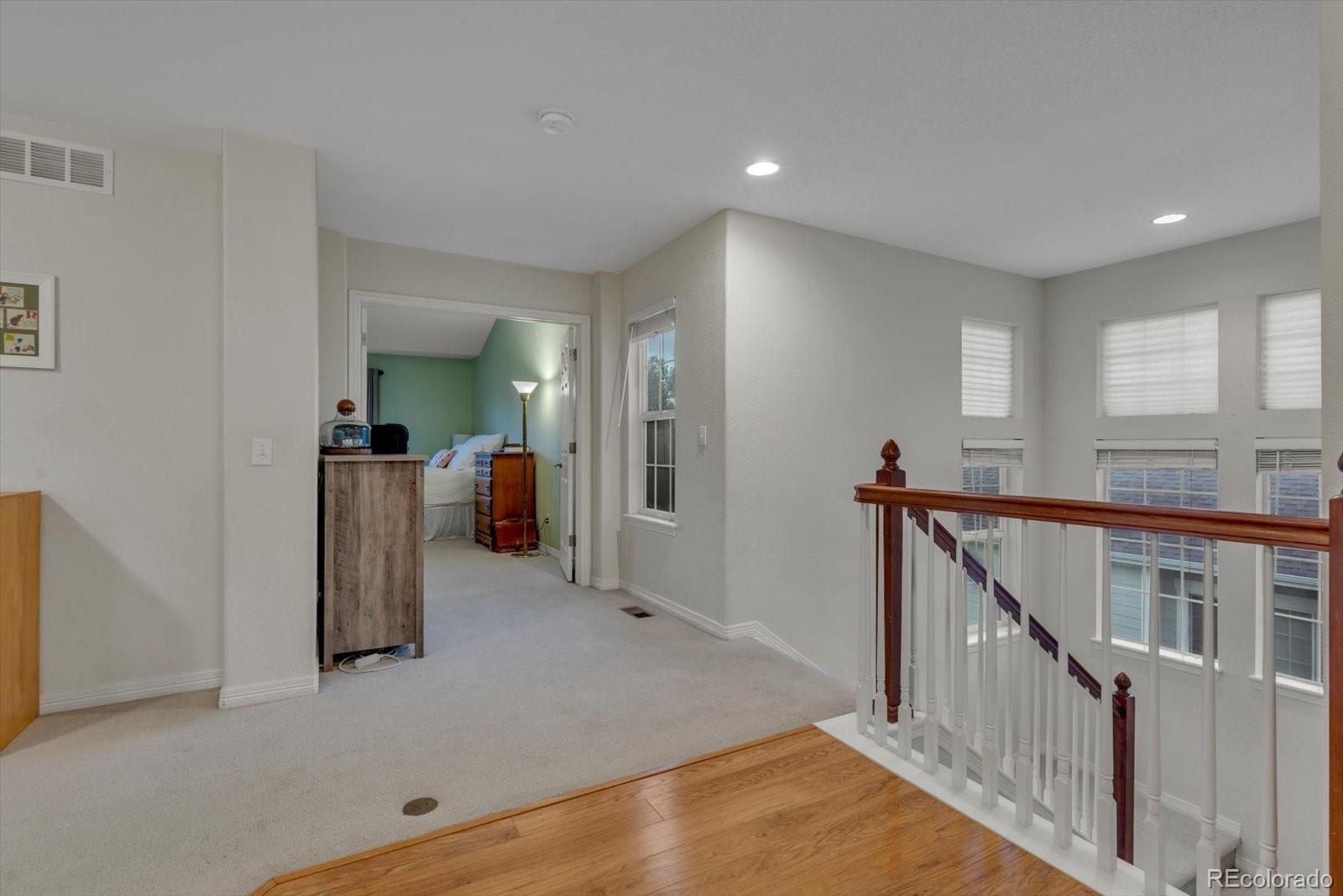 4786 Rabbit Mountain Road Broomfield, CO 80020 - Photo 15 of 41 a view of hallway with stairs and wooden floor