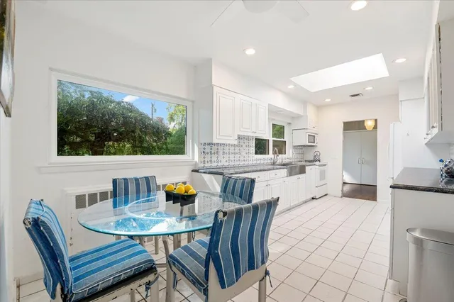 a open dining room with stainless steel appliances a table and chairs