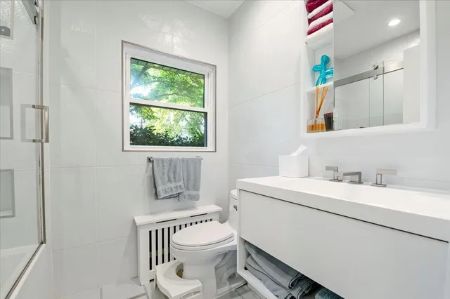 a bathroom with a granite countertop toilet sink and mirror