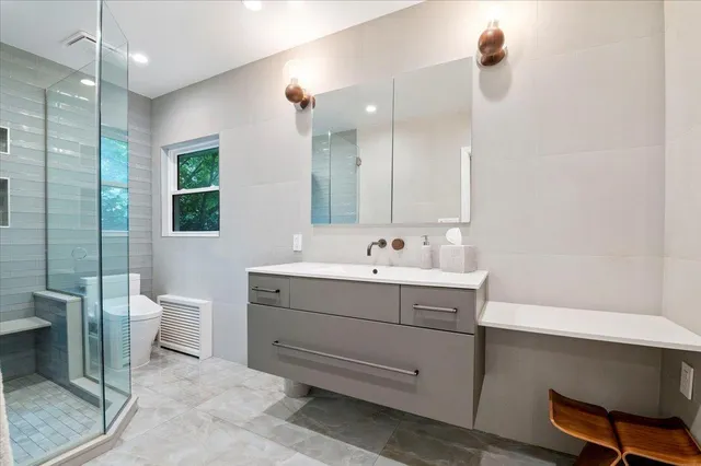 a bathroom with a sink a toilet and shower