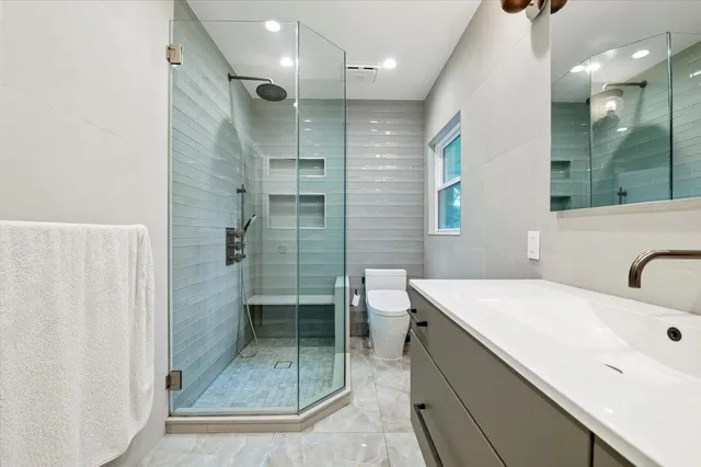 a bathroom with a shower sink and mirror