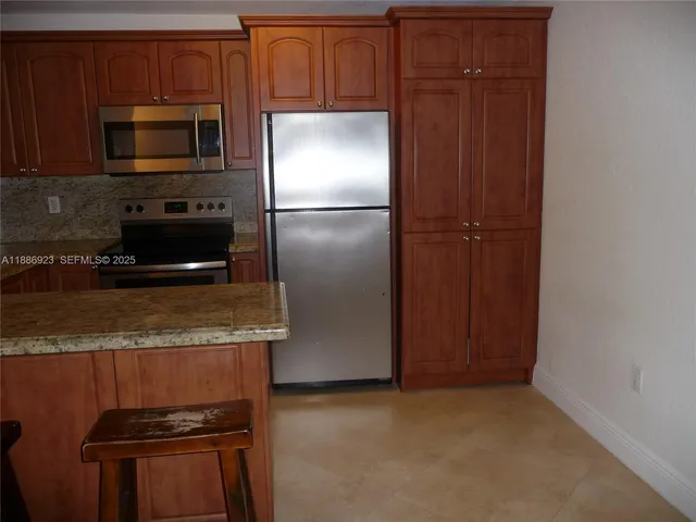 a kitchen with granite countertop stainless steel appliances and wooden cabinets