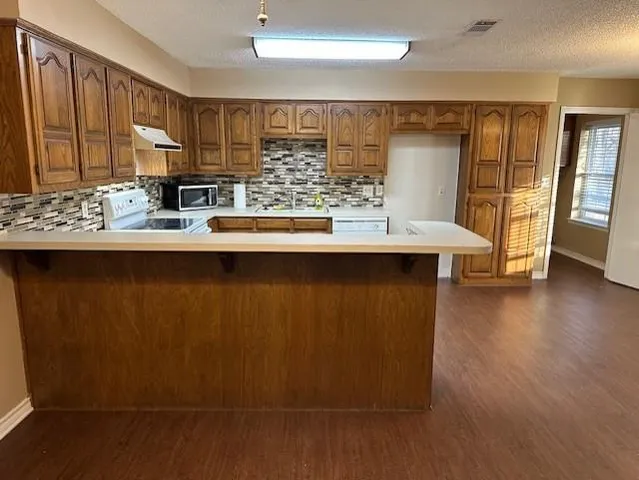 a kitchen with stainless steel appliances a sink window and wooden floor