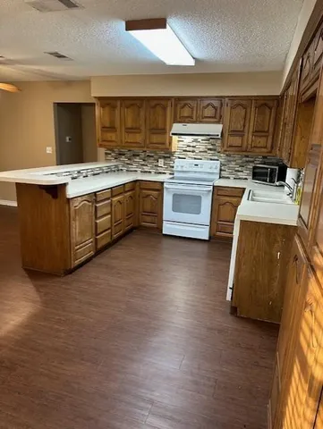 a large kitchen with stainless steel appliances a stove a sink dishwasher and a oven