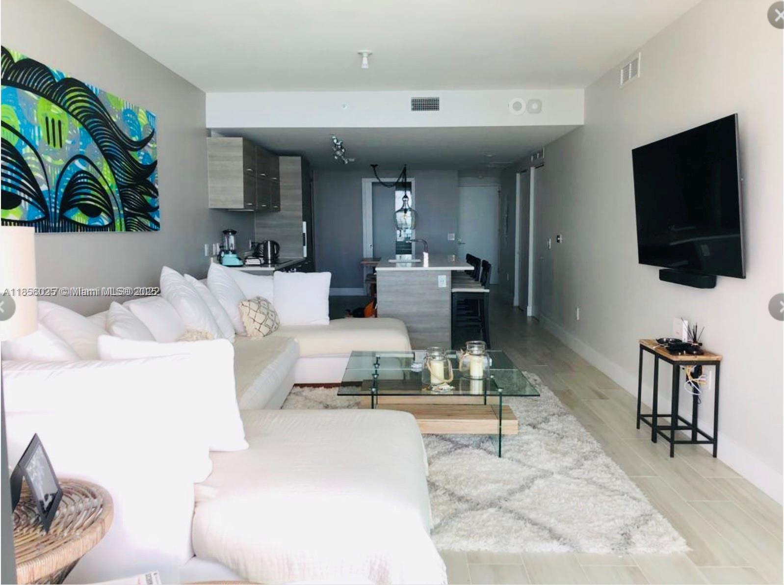 650 Northeast 32nd Street, Unit 4003 Miami, FL 33137 - Photo 12 of 32 a living room with furniture and a flat screen tv