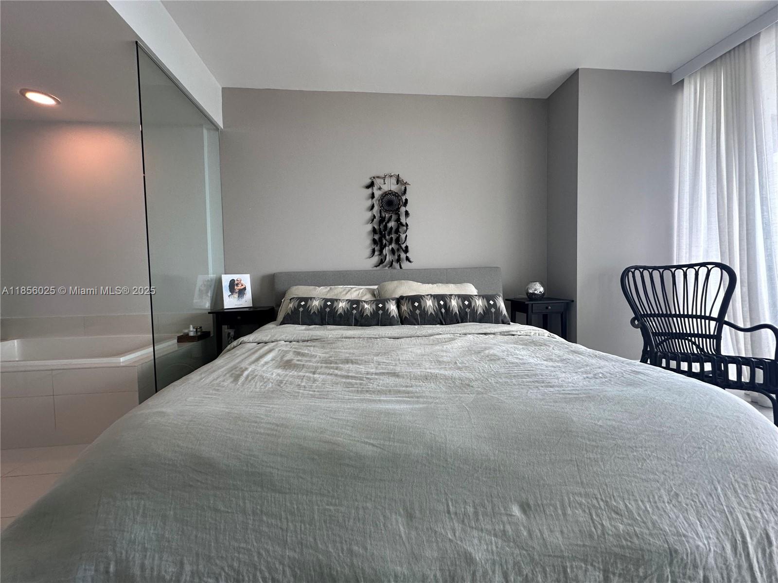 650 Northeast 32nd Street, Unit 4003 Miami, FL 33137 - Photo 14 of 32 a bedroom with a bed and a chair