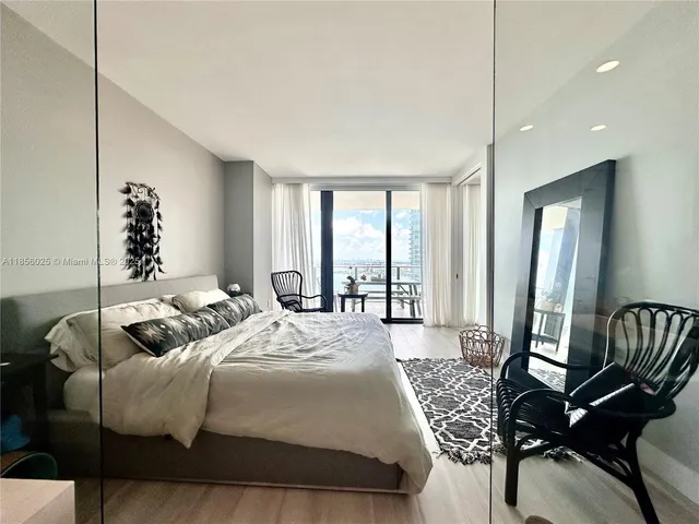 a bedroom with furniture and a large window